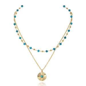 Dettaglio della collana doppia dorata con perline blu e ciondolo tondo a raggiera