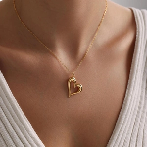 Close-up of a double-layered gold heart pendant necklace on a woman's collarbone