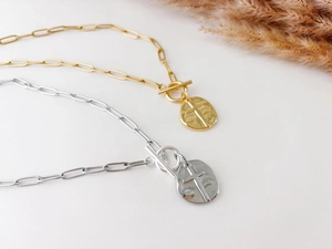 Detail of paperclip chain necklaces with OT toggle clasp and cross pendant in gold and silver
