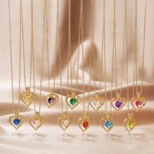 Detail of twelve colorful heart birthstone pendants with gold rose on silk background