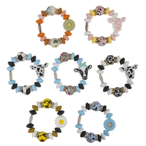Pulseras de cuentas de silicona con motivos de girasol y vaca sobre un fondo blanco