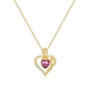 Macro detail of 18K gold heart pendant with pink gemstone and small rose accent