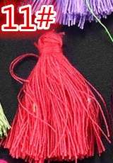 Macro detail of vibrant red cotton tassels for DIY crafts and bookmark accessories
