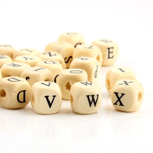Macro shot of 10mm square wooden alphabet beads with black letters for DIY jewelry making