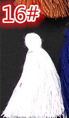 Detailed close-up of white decorative cotton tassel with round knot on black background