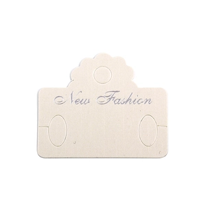 Dettaglio del cartoncino beige per orecchini con testo New Fashion argento e foro appeso