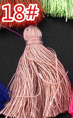 Close-up of a pink decorative textile tassel with silk threads for DIY craft accessories
