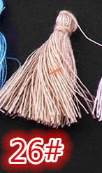 Macro detail of vertical silk tassel pendant in dusty pink with tie knot finish
