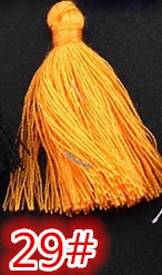 Detail of bright orange DIY craft tassel pendant with tied top and vibrant 29# thread
