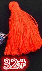 Macro view of bright orange vertical silk tassel with decorative knot texture