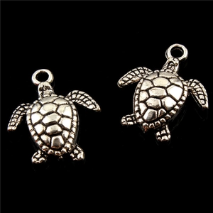 Macro detail of antique silver turtle charms for jewelry making with vintage shell patterns