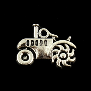 Macro shot of vintage silver alloy tractor pendant with detailed metallic texture