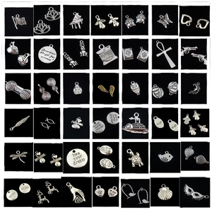 Assorted vintage silver alloy charms set with inspirational engravings on black background