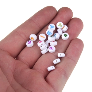 Bunte Alphabet- und Herzperlen aus Acryl in der Handfläche für DIY-Schmuckherstellung