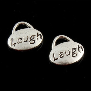 Vista dettagliata di due ciondoli ovali in lega argento con incisione Laugh su nero