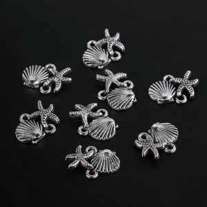 Macro detail of retro silver alloy starfish and seashell jewelry connectors for DIY crafts