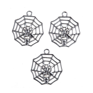 Macro view of vintage silver alloy spider web pendants with miniature skull details