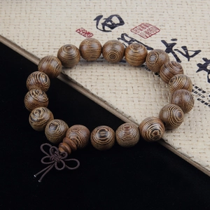 Macro shot of natural wenge wood beads featuring authentic textures and a silk tassel