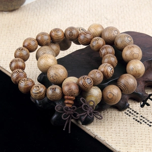 Natural wood prayer beads bracelet with handmade knot on traditional wooden stand