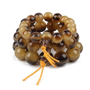 Macro detail of natural wood grain beads with multi-layer wrap and yellow knot cord