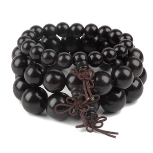 Macro shot of dark brown wooden prayer beads with decorative Chinese knots