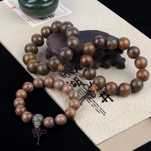 Close-up of natural wood prayer beads with traditional tassels on a vintage base