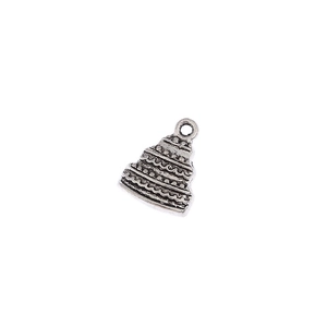 Macro shot of vintage silver alloy tiered cake charm with wave and dot textures