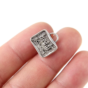 Dettaglio ravvicinato del ciondolo in argento vintage con scritta beads of COURAGE
