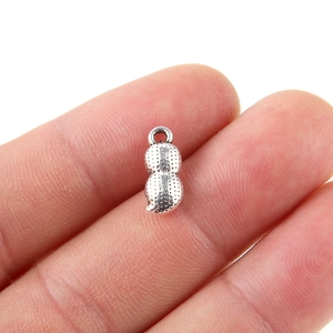 Detailed close-up of a silver peanut-shaped metal pendant charm for DIY jewelry making