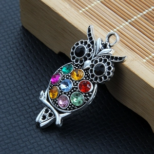 Detail of owl pendant with multi-color rhinestones and retro silver metal finish