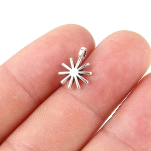 Macro shot of silver star-shaped pendant charm held in hand for jewelry making