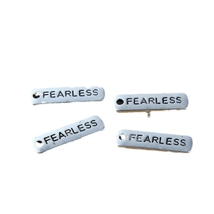 Pendaglio d'argento con incisione Fearless, quattro targhette in metallo su sfondo bianco
