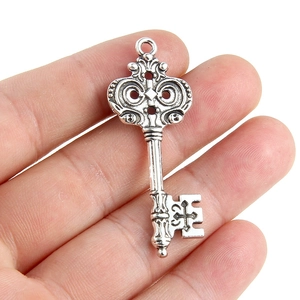 Gros plan d'un pendentif clé vintage en alliage argenté avec détails de croix sculptée