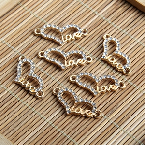 Vue macro de 5 connecteurs Love en forme de cœur dorés avec cristaux pour bijoux