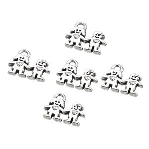 Detailed view of antique silver alloy charms featuring a boy and girl for DIY jewelry