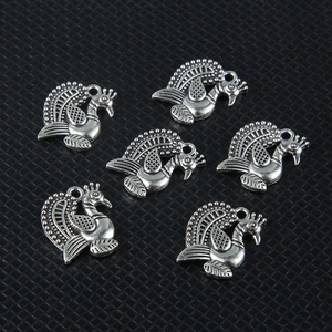 Detailed macro view of six vintage silver peacock pendants for DIY jewelry crafting