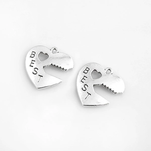 Vue détaillée de deux pendentifs cœur puzzle avec gravure BEST et finition argent poli