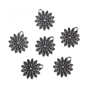 Detail of six antique silver sunflower pendants with textured double-layered petals