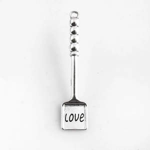 Vue détaillée d'un pendentif pelle en métal argenté avec une inscription LOVE gravée