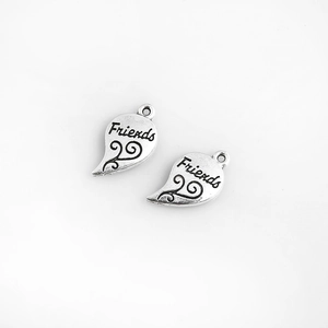 Vue détaillée des pendentifs cœur en puzzle argenté avec gravure Friends et motifs