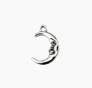 Detailed close-up of a vintage crescent moon face alloy pendant for DIY jewelry making
