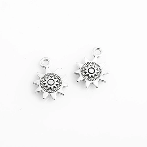 Detailed macro view of two sun-shaped silver alloy pendants for DIY jewelry crafting