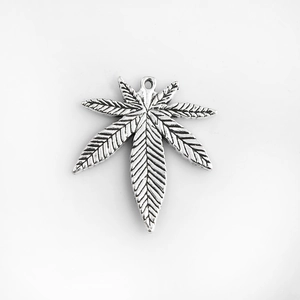 Macro d'un pendentif feuille en métal argenté avec texture pour création de bijoux