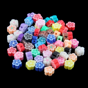 Perles fleurs colorées en pâte polymère pour bijoux DIY sur fond noir élégant