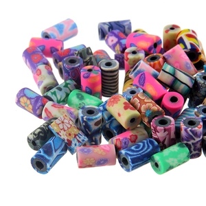 Détail de perles colorées en pâte polymère aux motifs floraux et marbrés pour loisirs créatifs