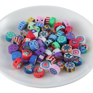 Gros plan de perles colorées en pâte polymère aux motifs variés pour bijoux artisanaux