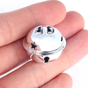Detailopname van kleine zilveren metalen bel met sterpatroon voor kerstversiering