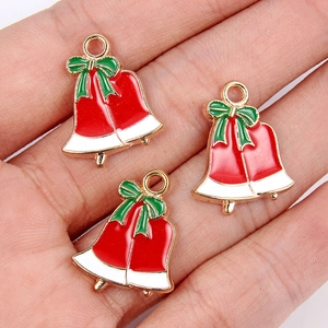 Detail van rood-witte emaille kerstbelhangers met groene strikken voor DIY-sieraden