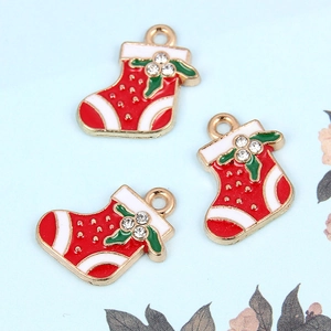 Detailweergave van drie metalen kerstsok hangers met kleurrijk emaille en strass-steentjes