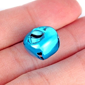 Close-up van een glanzende blauwe metalen kerstbel vastgehouden voor DIY-knutselwerkjes